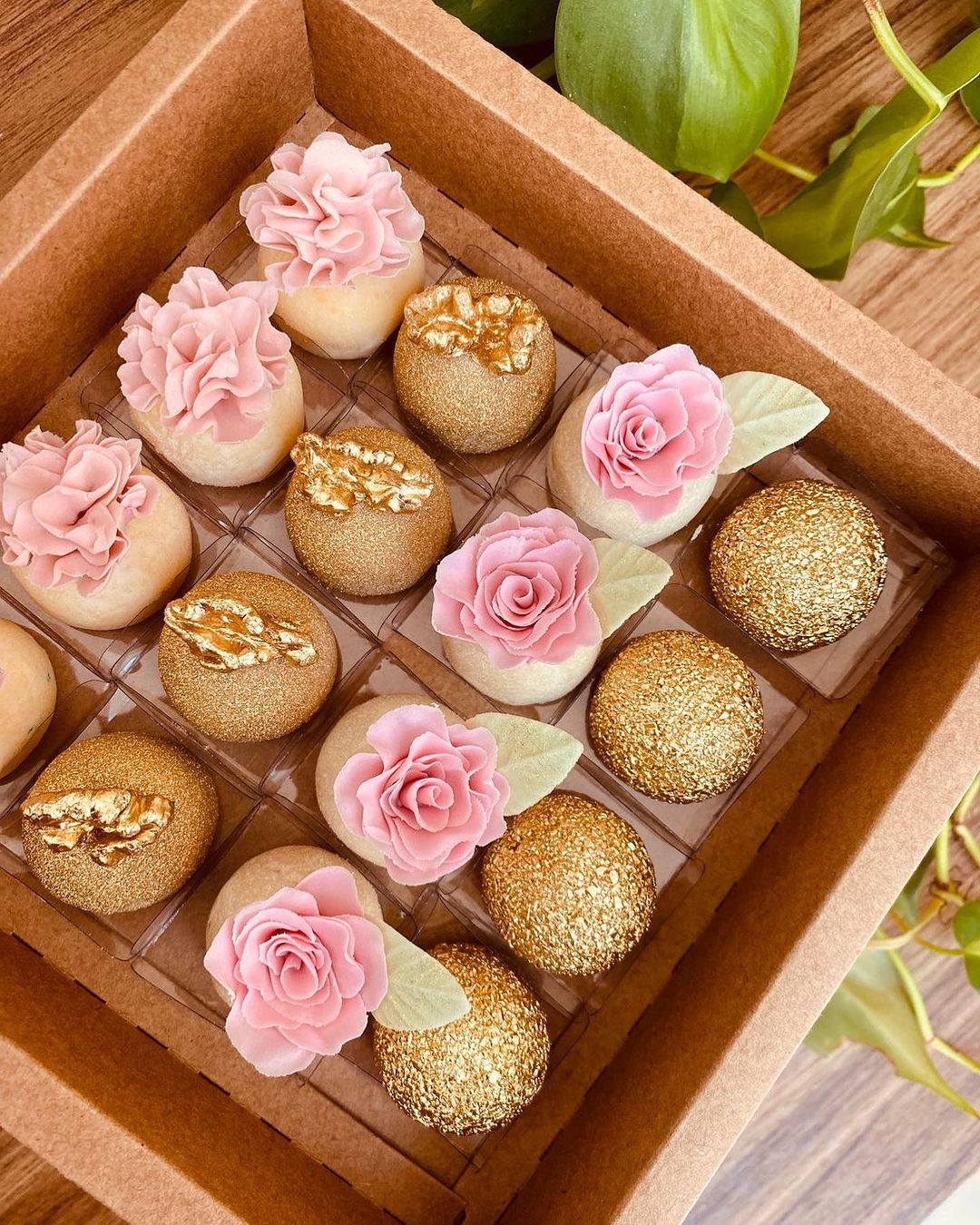 Caixa com doces finos dourados e rosas de açúcar