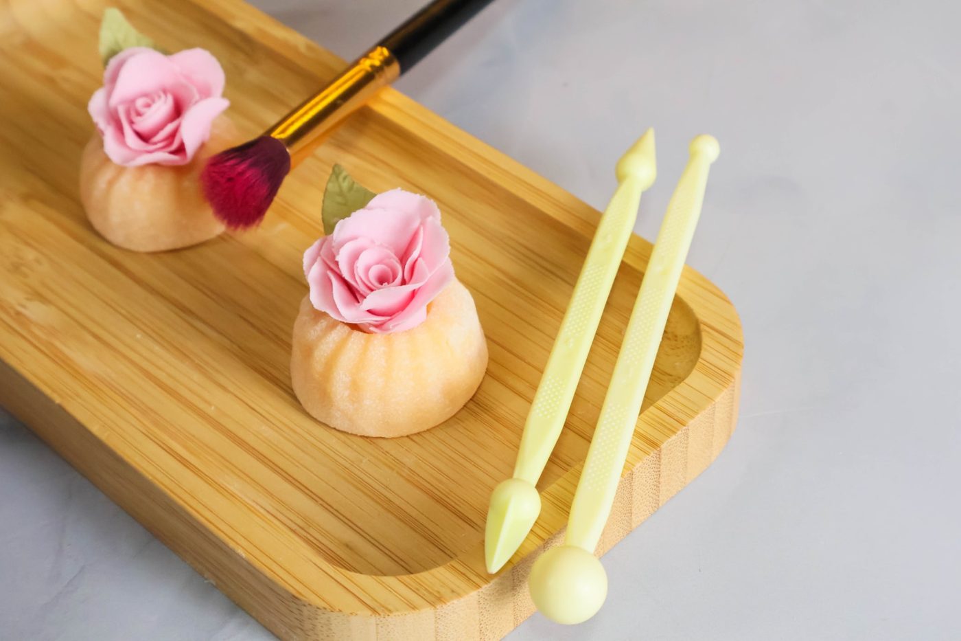 Doce fino com rosa de açúcar rosa sobre bandeja de bambu
